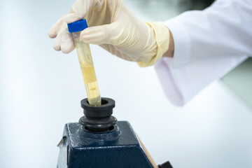 Chemistry or scientist mix the solution of the plastic test tube by press the tube on the rubber cup of vortex machine in the laboratory . Selective focus. Research and pharmaceutical lab concept.