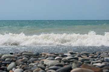 The Sea Wave of the Black Sea is a pebble beach. Smooth horizon, blue sky.