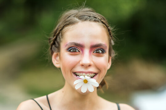 Fummy happy young woman with daisy flower in mouth. Beauty Spring. Springtime. Youth, flowering blossom.