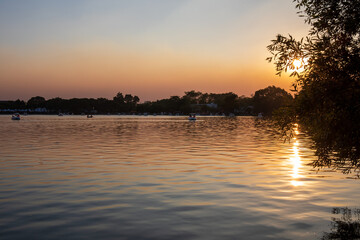 People ride duck boat at public park name Suan Luang Rama IX on sunset time Bangkok, Thailand.