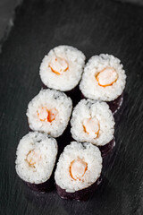 appetizing sushi shrimp maki roll on a black stone plate