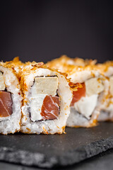 appetizing sushi roll with tuna cheese and tofu on a black stone plate