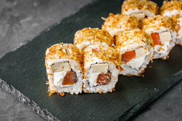 appetizing sushi roll with tuna cheese and tofu on a black stone plate