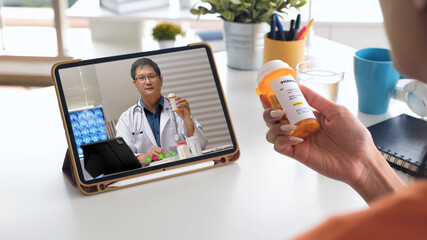 telehealth concept,asian woman video call with her doctor about prescription while staying at home....
