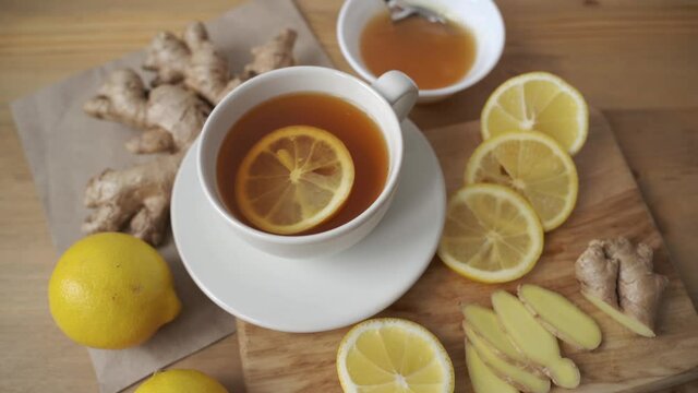 Adding lemon to cup of ginger tea. Alternative medicine herbal tea