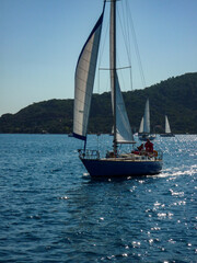 sail boat yacht in race regatta with mountain background
