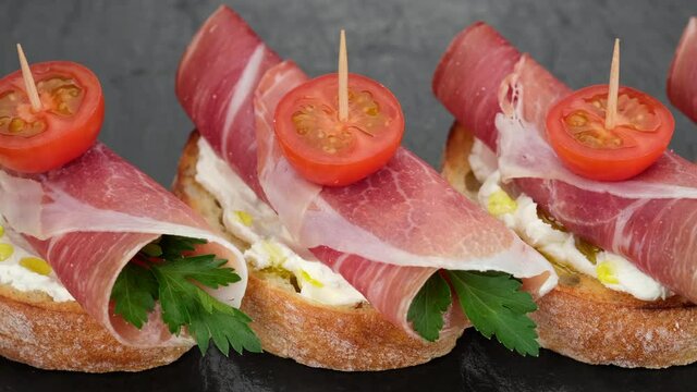 bruschetta with italian prosciutto or spanish jamon top view. stylish snack with ham