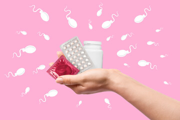 Hand with different contraceptive means on color background