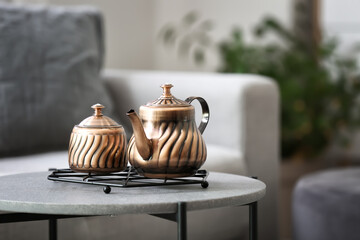 Tray with teapot and sugar bowl on table in room