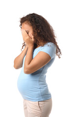 Stressed pregnant African-American woman on white background