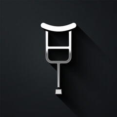 Silver Crutch or crutches icon isolated on black background. Equipment for rehabilitation of people with diseases of musculoskeletal system. Long shadow style. Vector.