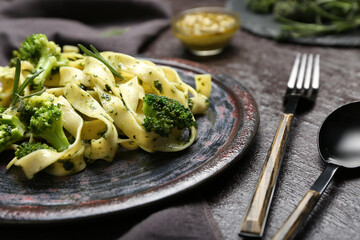Delicious pasta with broccoli on dark background, closeup