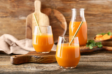 Glasses of fresh carrot juice on wooden table