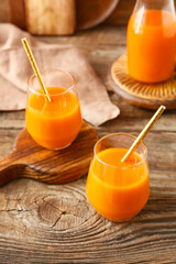 Fresh carrot juice on wooden background