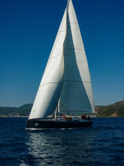 Fototapeta premium sail boat yacht in race regatta with mountain background