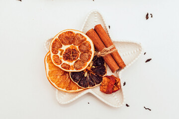 Ingredients of a mulled wine recipe on a white background with a text space - a Christmas or winter warming drink. orange, cinnamon sticks, anise, nutmeg, cloves in a mulled wine glass