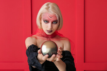 Fortune teller with magic ball on color background