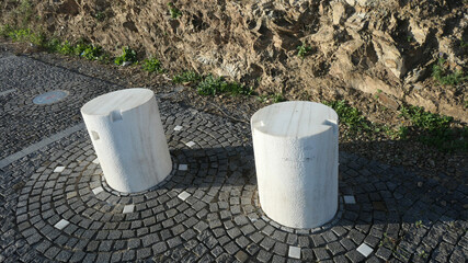 Curious arrangement of squat marble pillars in circular cobbled pavement