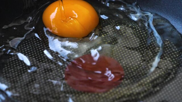 Close up slow motion video for the egg frying in the hot iron panto make fried egg for the breakfast 