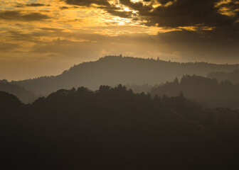 Distant hills during sunset, many layers of depth and color, from greys to orange, the place is the rolling hills in Chiba, Japan