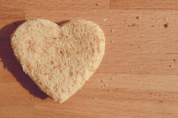 Grained bread cut off as heart shape. Concept of love and care in Valentine day.