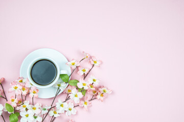 A cup of black aromatic coffee with pink flowers