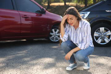 Stressed woman near cars after traffic accident outdoors
