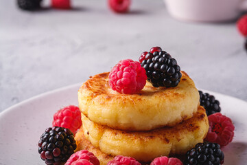 Cottage cheese pancakes, curd fritters dessert with raspberry and blackberry berries