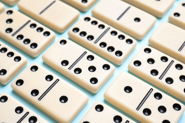 Set of classic domino tiles on light blue background, closeup