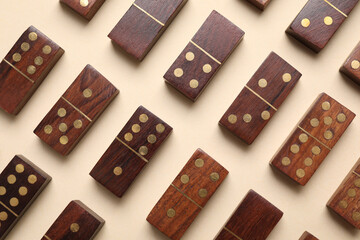 Wooden domino tiles on beige background, flat lay