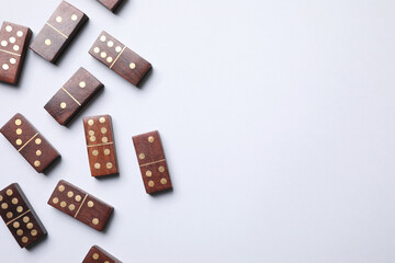 Wooden domino tiles on white background, flat lay. Space for text