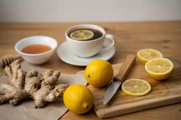 Cup of ginger tea with honey and lemon on wooden table