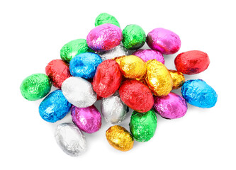 Fototapeta na wymiar Many chocolate eggs wrapped in bright foil on white background, top view