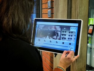 Une opticienne prenant les mesures d'une paire de lunettes sur le visage d'une femme