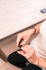 Young pregnant brunette performing a gestational diabetes self-test to control sugar. Bleeding blood from the finger