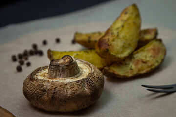 Fried food. Baked mushroom with potatoes on a wooden surface. Unhealthy food.