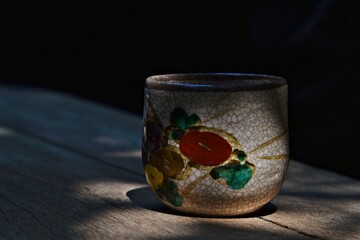 oriental style china ware tea cup on wood floor  in low light photography