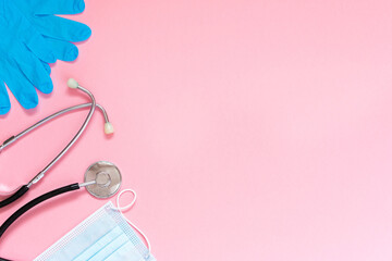 Stethoscope, rubber gloves and a protective mask on a pink background. Medical banner template with copy space, header layout. Health care and medical concept.