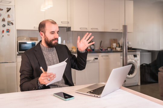 New normals during the coronavirus pandemic, businessman boy working from home waving on video call