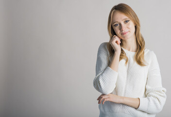 Portrait of a stylish and smiling girl on a white background in the studio with a place for writing...