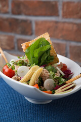 Grilled chicken salad with baby corn, pepper, tomatoes and greens