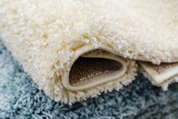 Large pile carpet on the counter in the store. Detail of a floor covering made of light-colored...