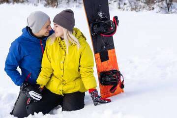 Fototapeta na wymiar Portrait of happy couple of snowboarders outside during winter vacations