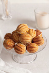 Russian traditional homemade cookies Nuts with condensed milk on a glass stand. White background, selective focus