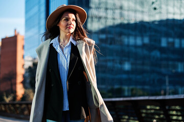 Fototapeta premium Stylish woman standing outdoors on a bridge.