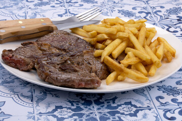 basse côte de boeuf grillée et frites dans une assiette