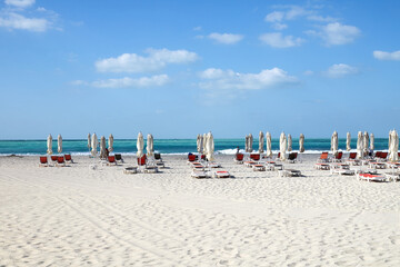 An empty beach near Abu Dhabi with turquoise water and umbrellas