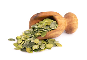 Pumpkin seeds in wooden scoop, isolated on white background. Green pepita seeds.