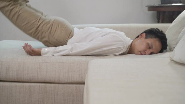 Exhausted overloaded young man in casual shirt came home after work flopped down on sofa feels like squeezed lemon. Concept of after party, tired overworked person hard day, lack of energy, breakdown