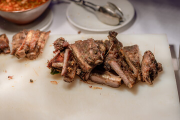 Roasted sliced barbecue pork ribs. Barbecue spare ribs St Louis cut with hot honey chili marinade sliced as top view on an old rustic board 